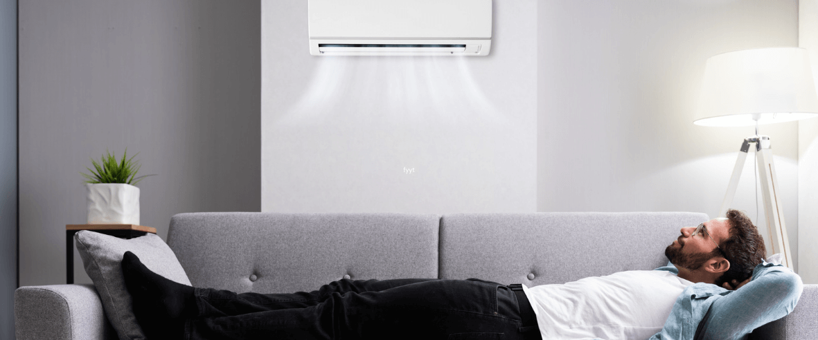 A man lays down on the couch and enjoys the air conditioning from his condo ac