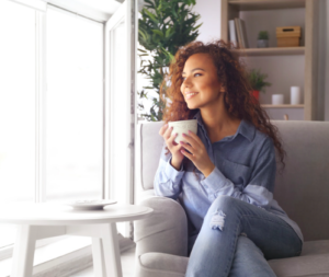 A woman drinks coffee and looks out the window