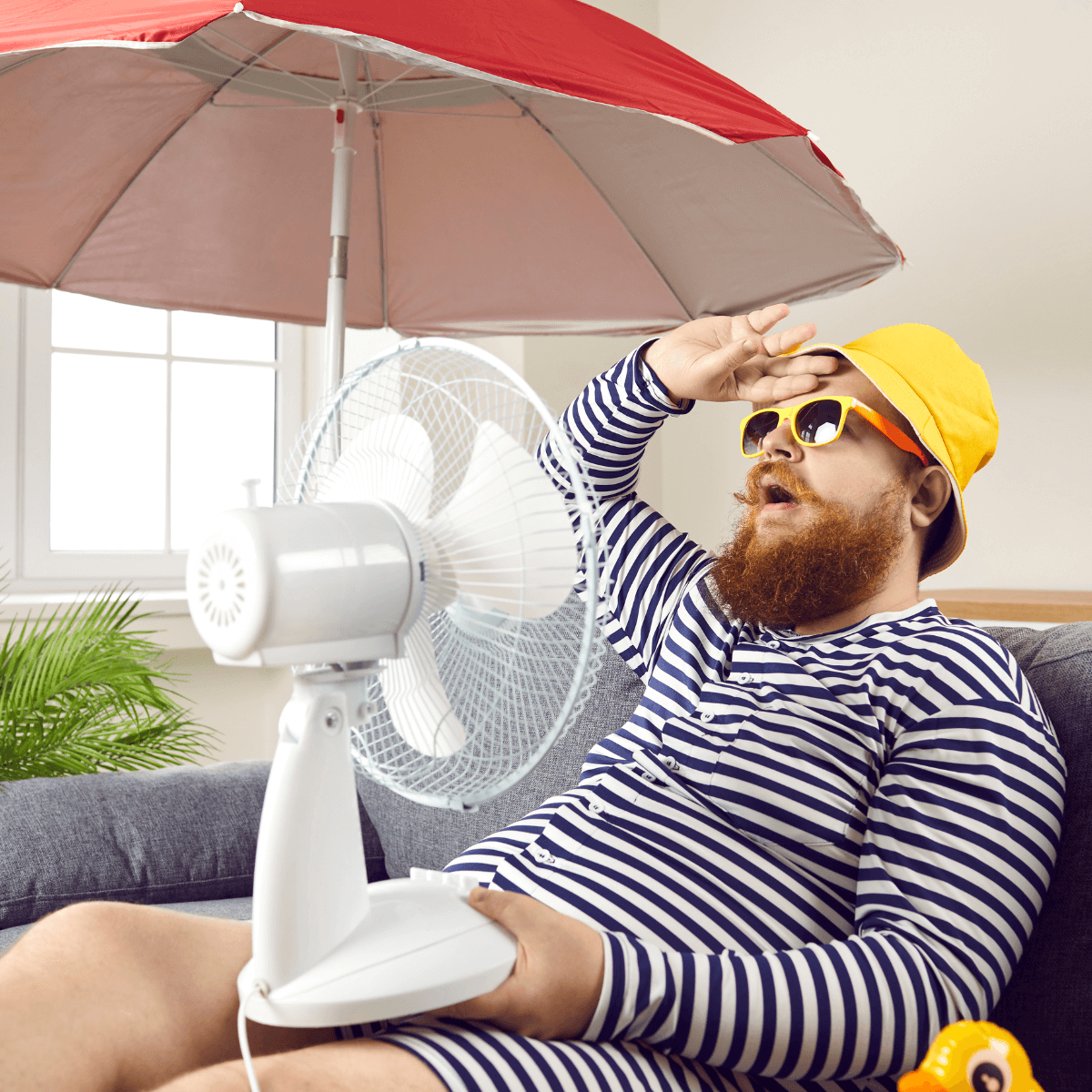 A man with a beard sweats in his hot condo because his condo ac needs repair