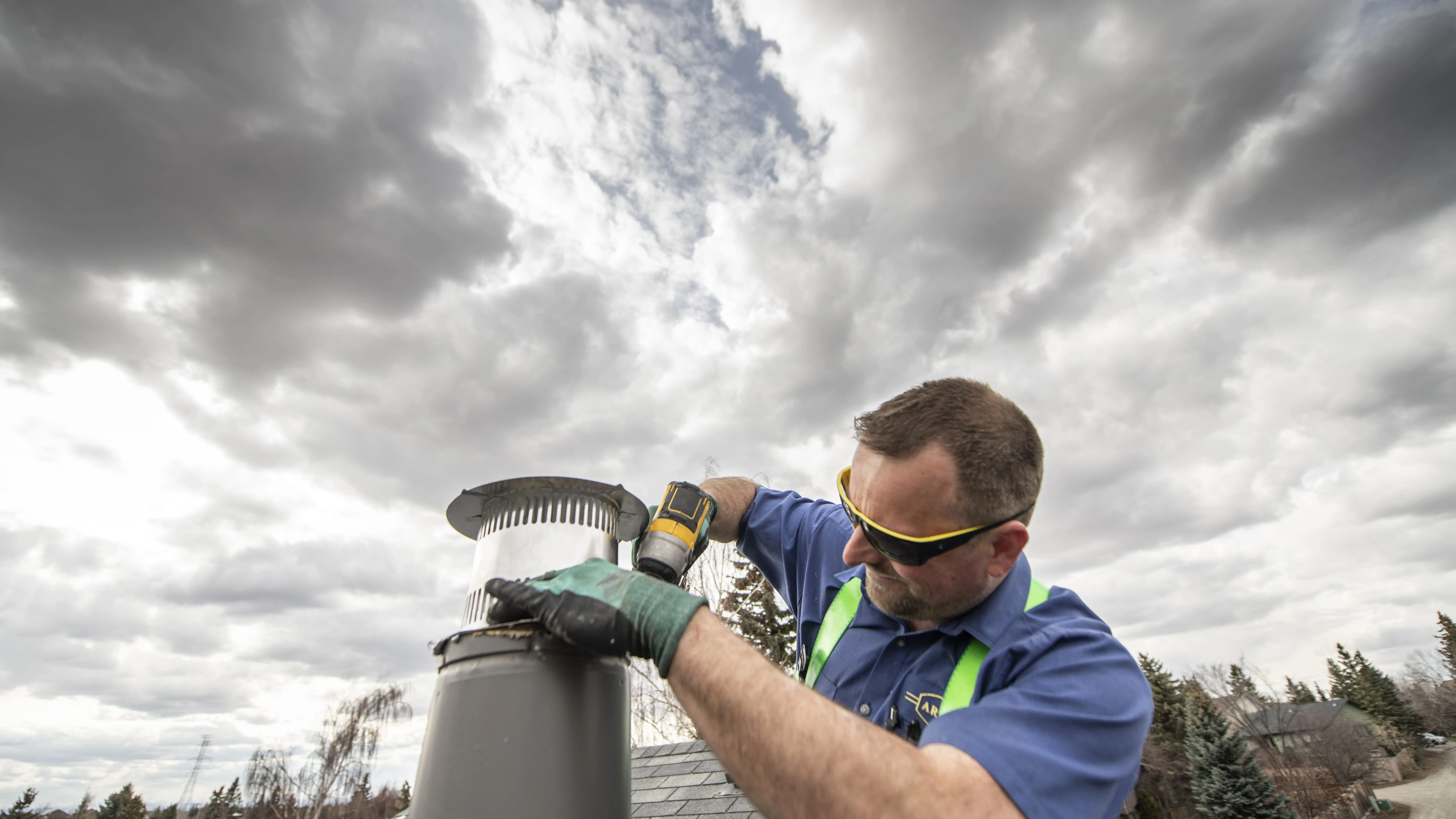Arpi's technician installing a furnace exhaust vent cap on a Calgary rooftop during a new furnace installation